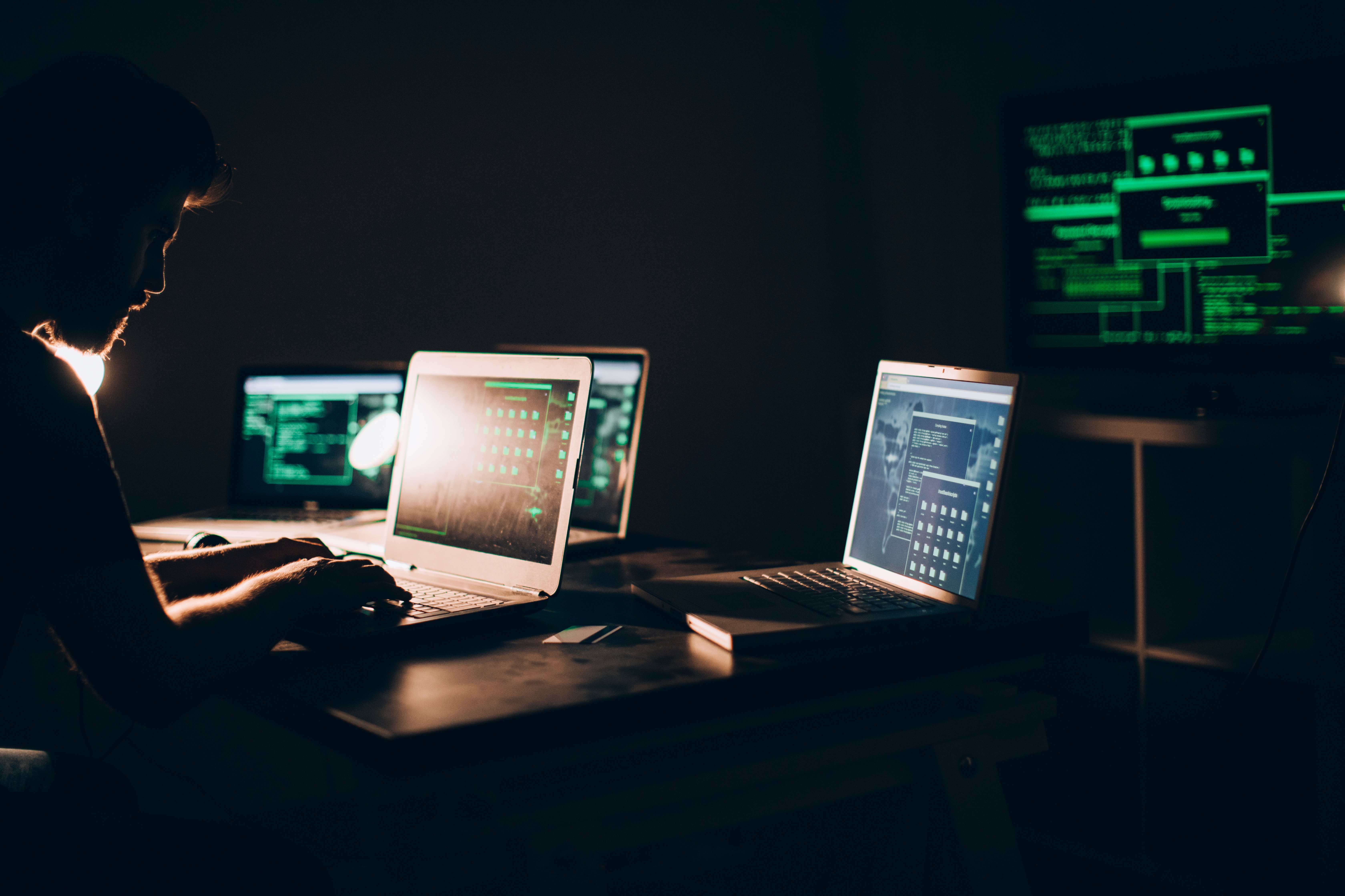 Man looking at multiple laptops for IT services